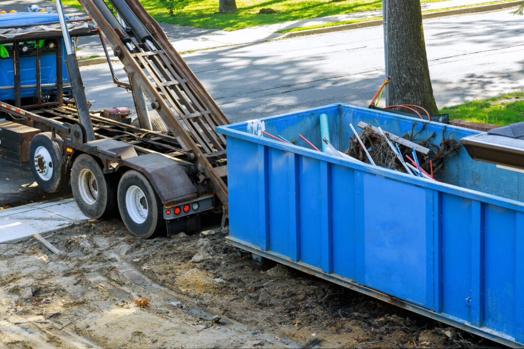Junk removal truck picking up a dumpster
