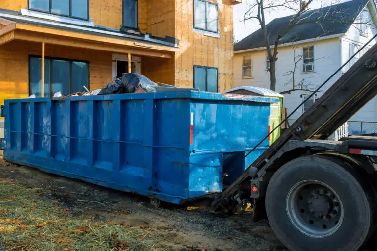Junk removal truck picking up a dumpster