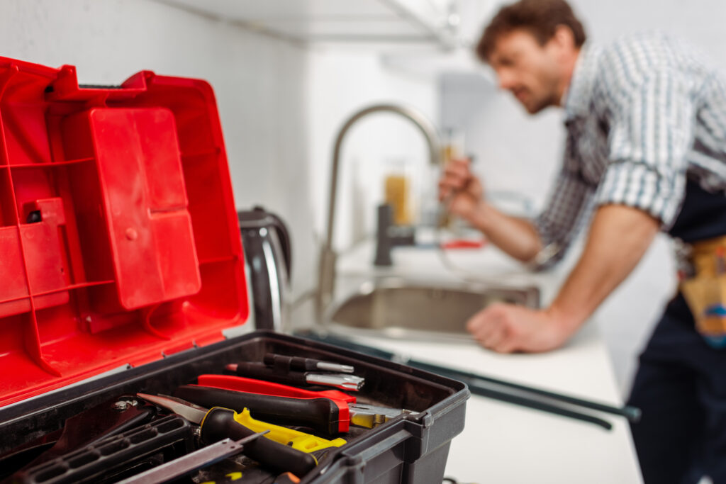 Plumber repairing a faucet after digital marketing for plumbing filled his calendar.