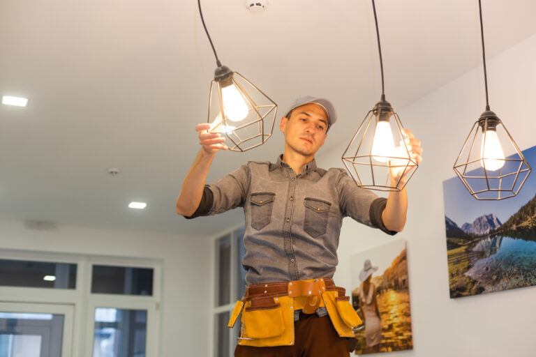 Electrician worker installation electric lamps light inside apartment. Construction decoration concept after Tampa electrician PPC services filled their schedule.