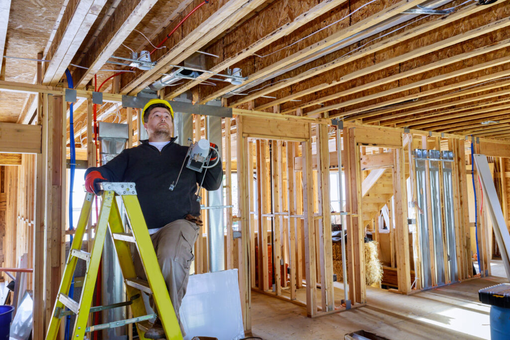 Electrician performing rough-in wiring in new construction after electrician SEO services in Tampa FL booked his calendar