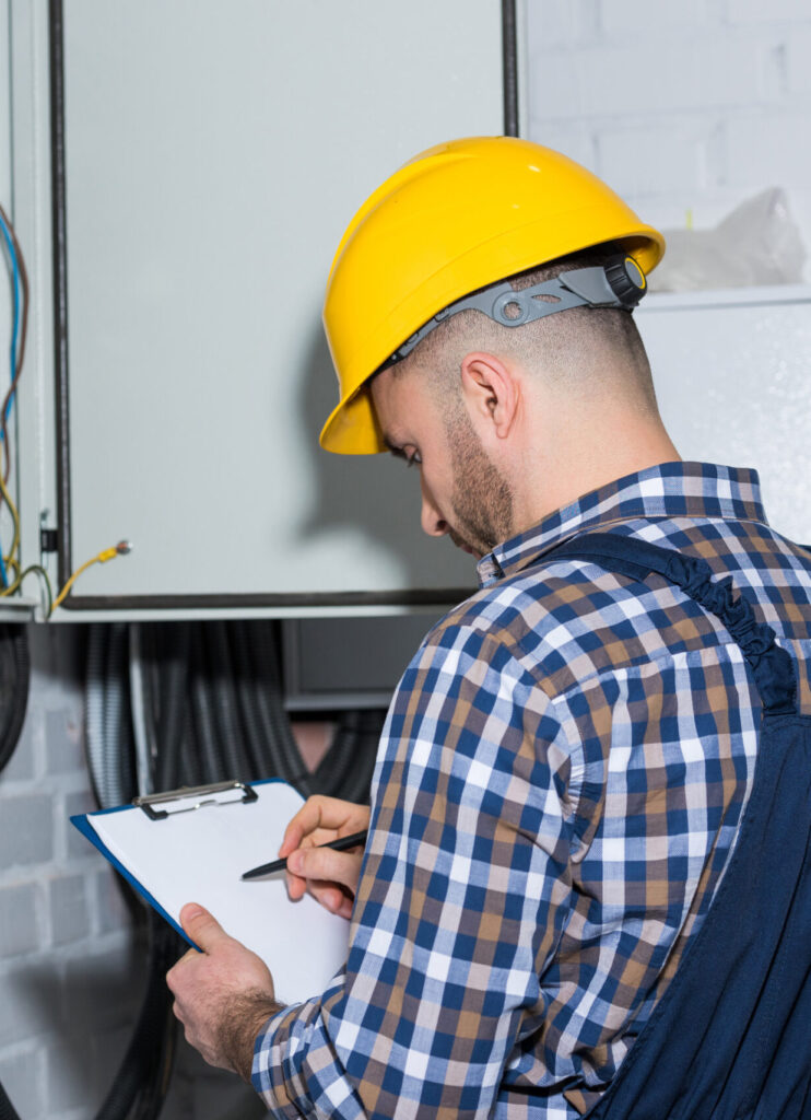 Electrician inspecting electrical panel during audit after electrician SEO services in Tampa FL filled his schedule