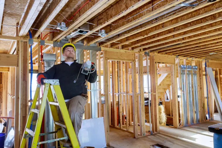 Electrician is holding in his hands installs and mounts the interior lighting on the ceiling after home services SEO filled their calendar with work.
