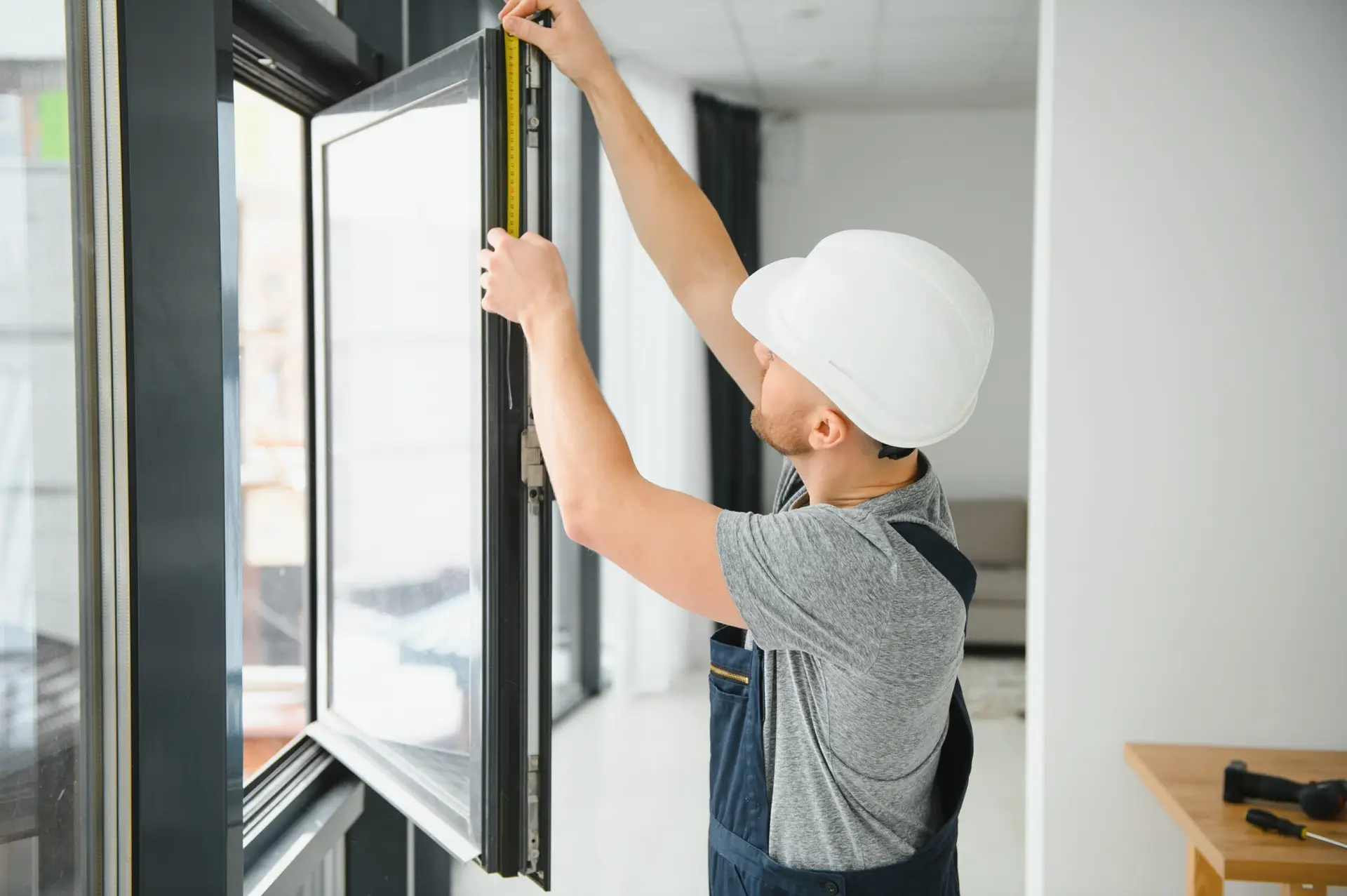young man installing bay window in new house construction site after home services SEO filled their calendar with work.