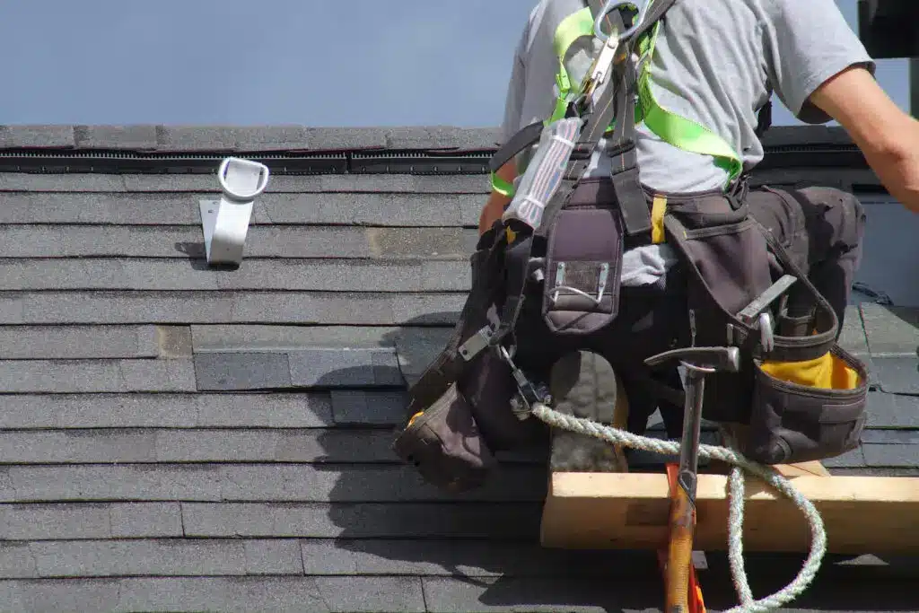 roof repair construction worker fixing a roof after securing roofing leads.