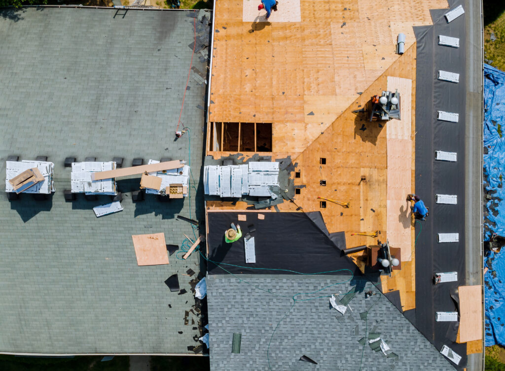A roofer nailing shingles with air gun, replacing roof cover protection being applied after after roofing web design services created a site that filled their calendar with work.
